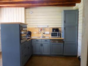 a kitchen with blue cabinets and a sink at Maison bourgeoise éco-gîte, spa, barbecue, jardin, 2 chambres près de Vichy et Moulins - FR-1-489-290 in Bransat
