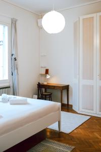 Un dormitorio blanco con una cama y un escritorio. en SM Hospitality MONTE PASUBIO, en Reggio Emilia