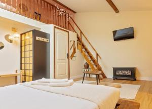 a bedroom with a bed with a fireplace and a staircase at Maison Mori in Vienne