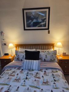 a bedroom with a bed with a comforter and two lamps at St Michael's Boutique Guest House, North Bay, Scarborough with free parking and fast wi-fi in Scarborough