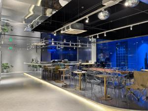 Una habitación con mesas y sillas y paredes azules. en Third Floor Youth Hostel, en Shanghái