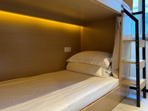 Litera en habitación pequeña con escalera en Third Floor Youth Hostel, en Shanghái 9 fotos más