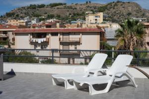 two white chairs sitting on top of a roof at La Terrazza di Porticello in Porticello