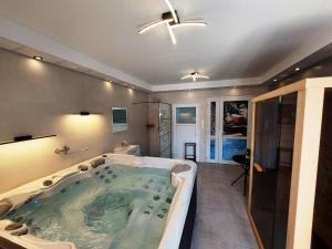 a large bath tub in a bathroom with a shower at Lipicai Hotel és Étterem in Szilvásvárad +103 photos