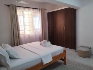 a bedroom with a bed with a box on it at Erwin Holiday Homes in Diani Beach +30 photos
