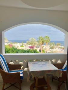 a room with a table and chairs and a view of the ocean at Sea View Apartment with Full kitchen and living room in Sharm El Sheikh