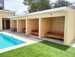 a house with a swimming pool and green grass at Erwin Holiday Homes in Diani Beach