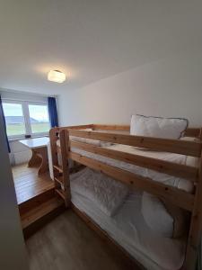 Letto a castello in legno in una camera con finestra di Strandhotel Wohnung 4 a Dahme