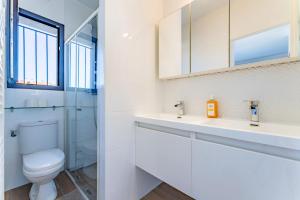 ein Bad mit einem WC, einem Waschbecken und einem Spiegel in der Unterkunft La maison Barthe design 4ch clim parking privé in Toulouse + 14 Fotos