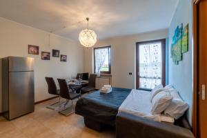 Residenza Prezzemolo في كاستلنوفو ديل جاردا: غرفة بسرير وطاولة وثلاجة