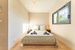 ein Schlafzimmer mit einem großen Bett mit Fenster in der Unterkunft La maison Barthe design 4ch clim parking privé in Toulouse