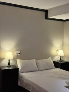 a bedroom with a white bed with two lamps at HY Local Budget Hotel - 5 mins walk to Hoi An Ancient Town in Hoi An