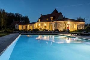 a house with a swimming pool in front of a house at Domaine Le Rucher des Combes in Fleurac