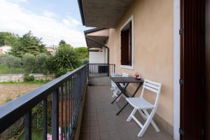 Residenza Prezzemolo في كاستلنوفو ديل جاردا: بلكونه عليها طاوله وكراسي