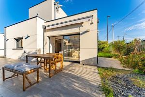 ein weißes Haus mit einem Tisch und Stühlen auf einer Terrasse in der Unterkunft La maison Barthe design 4ch clim parking privé in Toulouse