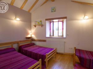 two beds in a room with purple sheets at Gîte spacieux avec jardin, terrasse, et parc proche du château - 6 pers., animaux acceptés - FR-1-496-102 in Fontanès