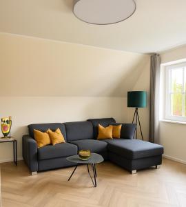 a living room with a couch and a table at MYROOM am Park in Lohne