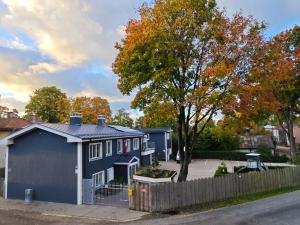 una casa azul con una valla y un árbol en Design Green Garden Apartments with Private Parking & Playground, en Riga