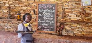 eine Frau steht vor einer Tafel in der Unterkunft 2 Friends Guest House in Jinja + 49 Fotos