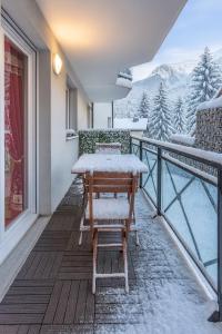 a balcony with snowcovered chairs and a view of the mountains at Alba Lodge, 2 min de la télécabine, vue montagnes in Brides-les-Bains +3 photos