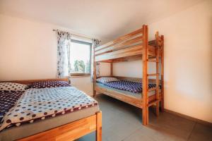 a bedroom with two bunk beds and a window at Čertova chalupa  +42 photos