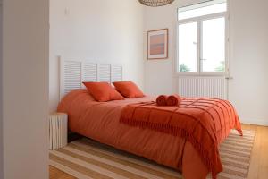 a bedroom with a bed with orange sheets and a window at Très belle maison avec extérieur - quartier la Chaume - 4 chambres 8 personnes in La Chaume