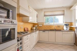 a large kitchen with white cabinets and a window at Très belle maison avec extérieur - quartier la Chaume - 4 chambres 8 personnes in La Chaume