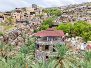 a house on a mountain with palm trees at Misfah Ambah house in Misfāh