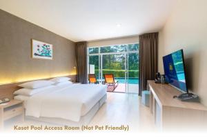 a hotel room with a large bed and a television at The Kaset, Hua Hin in Hua Hin