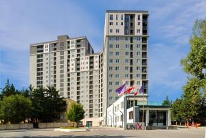 a tall white building with two flags in front of it at Jhonberi 5 in Tbilisi City
