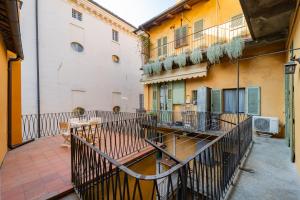 an apartment patio with a table and a balcony at La Terrazza in Centro Storico - Free Wifi & AC in Savigliano