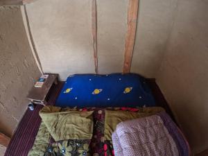 een kleine kamer met een bed en een koffer bij Cliff Seek in Kalgha +2 foto's