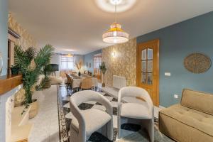 un soggiorno con divano e sedie di Villa Familiar l Piscina I Cine l Bbq l Sala de Juegos I 6min Segovia I 50min Madrid I 17 px a Valseca