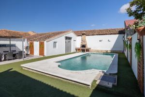 una piscina nel cortile di una casa di Villa Familiar l Piscina I Cine l Bbq l Sala de Juegos I 6min Segovia I 50min Madrid I 17 px a Valseca