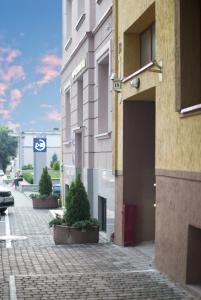 a building on a street with potted plants on the sidewalk at Hotel 18 in Lviv