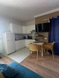 a kitchen with white cabinets and a table and chairs at Playa Paraiso Seaview in Adeje