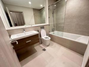 a bathroom with a toilet and a sink and a shower at HARF310 Modern Studio w Balcony at Yas Island in Abu Dhabi