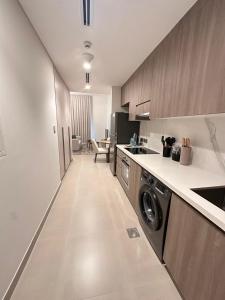a kitchen with a washer and dryer in it at HARF310 Modern Studio w Balcony at Yas Island in Abu Dhabi