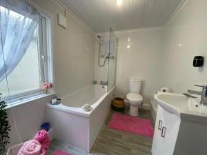 a bathroom with a tub and a sink and a toilet at Mercer House in Lisburn