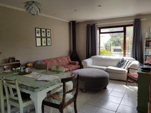 a living room with a table and a couch at Glen Valley Cottage in Glencairn