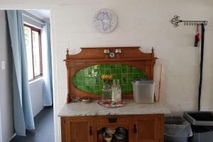 a room with a counter with a green tile wall at Glen Valley Cottage in Glencairn