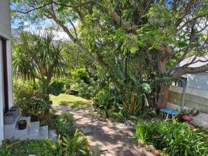 a garden with a bench and trees and plants at Glen Valley Cottage in Glencairn
