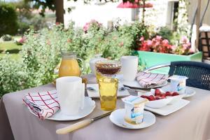 a table with plates of food and drinks on it at Au Paradis Des Hotes - Chambre Ile in Fouras