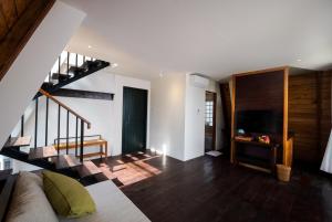 a living room with a couch and a staircase at Luxury Villas in Munduk at walking distance to Tamblingan Lake in Munduk
