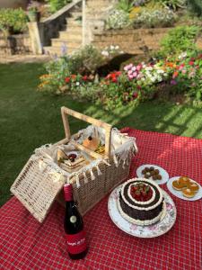 a picnic table with a bottle of wine and a cake at The Manor Hanthana in Kandy