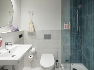 Un baño con ducha, inodoro y lavabo. en Numa Berlin Arc, en Berlín