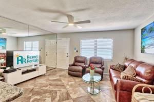 a living room with a couch and chairs and a tv at Sunset Chateau 506 - Premier in St. Pete Beach +29 photos