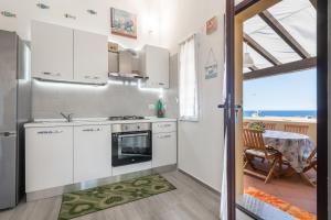 a kitchen with white appliances and a table and a dining room at Seb beach in Costa Rei