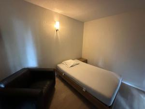 een kleine kamer met een bed en een bank bij Woodboxcabins - Campinggroenpark in Zele +4 foto's