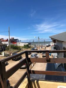 een balkon met een houten balustrade en uitzicht op de oceaan bij Complejo Gerar in Las Toninas